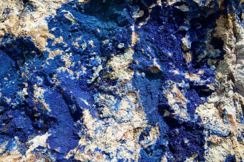 Close-up of vivid blue mineral embedded in pale, rough rock